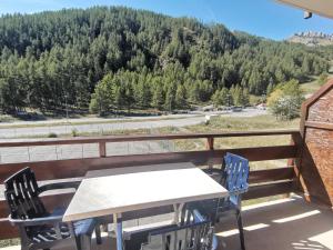 einen Tisch und Stühle auf einem Balkon mit Bergblick in der Unterkunft Boost Your Immo Gardette Réallon A11 in Réallon