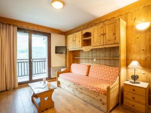 レ・メニュアールにあるApartment Balcons D'Olympie-5 by Interhomeの木製の壁のベッドルーム1室(ベッド1台付)