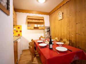 a kitchen with a table with a red table cloth at Apartment Balcons D'Olympie-5 by Interhome in Les Menuires