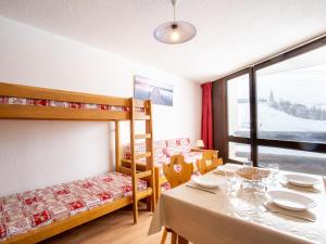 a dining room with a table and a bunk bed at Apartment Belleville Caron-7 by Interhome in Les Menuires