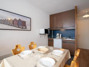 Apartment Belleville Caron-7 by Interhome في ليه مينوير: غرفة طعام مع طاولة وكراسي ومطبخ