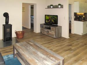 a living room with a tv and a wood stove at Apartment Helene by Interhome in Ribnitz-Damgarten