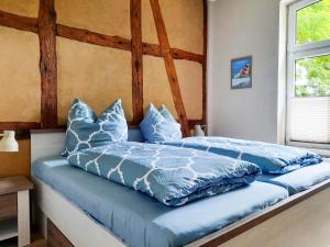 Una cama con edredón azul y almohadas. en Apartment Helene by Interhome, en Ribnitz-Damgarten