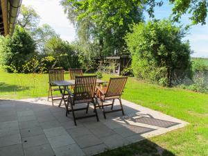 a patio with three chairs and a table with a table at Apartment Helene by Interhome in Ribnitz-Damgarten