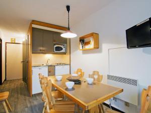 een keuken en eetkamer met een tafel en stoelen bij Apartment Le Villaret-2 by Interhome in Les Menuires