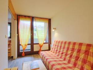 - un salon avec un canapé et une fenêtre dans l'établissement Apartment Le Villaret-2 by Interhome, aux Menuires