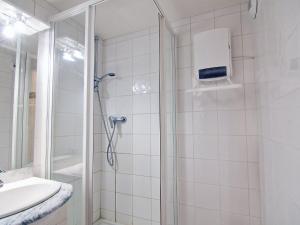 uma casa de banho com um chuveiro e um lavatório. em Apartment Le Villaret-2 by Interhome em Les Menuires