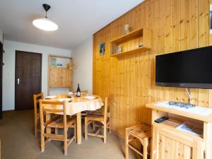 a dining room with a table and a flat screen tv at Apartment L'Astragale-8 by Interhome in Les Menuires