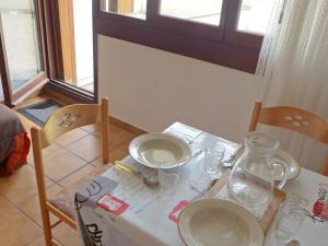 einen Tisch mit Brille und eine Vase drauf in der Unterkunft Apartment Les Olympiques-4 by Interhome in Les Boisses