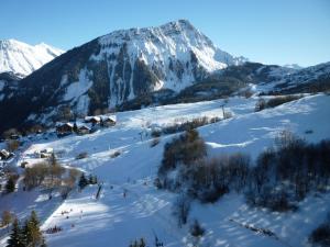 a snow covered mountain with people skiing down a slope at Apartment Vostok Zodiaque-55 by Interhome in Le Corbier