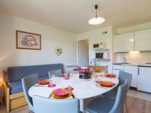 a dining room with a white table and chairs at Apartment Vostok Zodiaque-55 by Interhome in Le Corbier