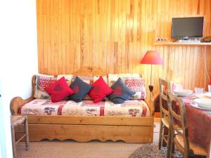 um quarto com uma cama com almofadas vermelhas e azuis em Apartment Bellard-2 by Interhome em La Toussuire
