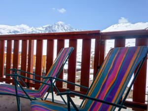 due sedie sedute su un ponte con montagne innevate di Apartment La Divaria by Interhome a Tignes