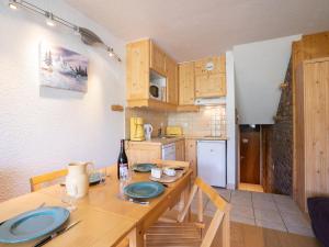 uma cozinha com uma mesa de madeira e uma sala de jantar em Apartment Brelin-9 by Interhome em Les Menuires