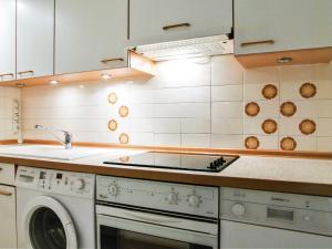 a kitchen with a stove and a washing machine at Apartment Le Bois du Bouchet-1 by Interhome in Chamonix
