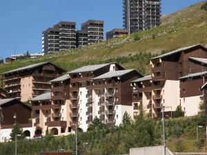an apartment building on a hill with tall buildings at Apartment L'Argousier-8 by Interhome in Les Menuires