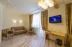 a living room with a couch and a television on the wall at Hata Hutsula in Mykulychyn