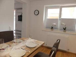 a dining room with a table and a clock on the wall at Apartment Stefanie by Interhome in Taxenbach