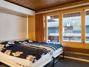 Schlafzimmer mit einem Bett und einem Fenster in der Unterkunft Studio Dixence 204 by Interhome in Les Collons
