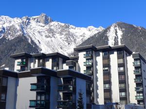 a building with mountains in the background at Apartment L'Aiguille du Midi-2 by Interhome in Chamonix