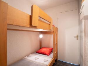 a small room with a bunk bed with a red pillow at Studio Le Médian-4 by Interhome in Les Menuires