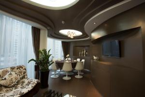 a dining room with a table and chairs and a tv at Guangzhou Planet Hotel in Guangzhou