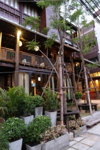 un edificio con árboles y plantas delante de él en Kampaeng Ngam Hotel - SHA Extra Plus, en Chiang Mai