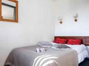 1 dormitorio con cama con almohadas rojas y espejo en Apartment Le Chamois Blanc-10 by Interhome en Chamonix-Mont-Blanc