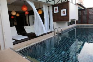 una piscina in una villa con una casa di Kampaeng Ngam Hotel - SHA Extra Plus a Chiang Mai