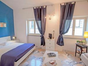 1 dormitorio con 1 cama y 2 ventanas con cortinas en Apartment Bufalini 2 - Raffaello by Interhome, en Florencia