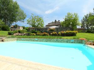 a swimming pool in front of a house with a garden at Apartment Aia by Interhome in Rapolano Terme