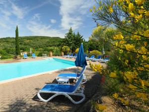eine Gruppe von Liegestühlen und einem Sonnenschirm am Pool in der Unterkunft Holiday Home Poggio Velluto by Interhome in Seggiano