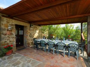 eine Terrasse mit einem Tisch und Stühlen unter einem Holzdach in der Unterkunft Holiday Home Poggio Velluto by Interhome in Seggiano