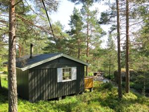 a cabin in the woods with trees at Holiday Home Berthabu - SOW116 by Interhome in Øyuvstad