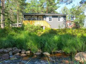 a house in the woods with a creek at Holiday Home Berthabu - SOW116 by Interhome in Øyuvstad