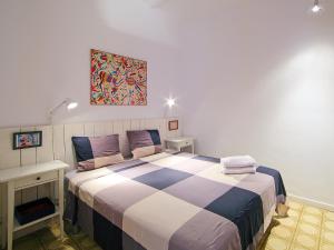 um quarto com uma cama grande e um cobertor xadrez em Apartment Eixample Dret Valencia - Cartagena by Interhome em Barcelona