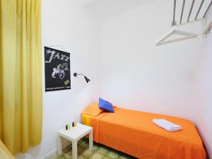 a bedroom with an orange bed and a side table at Apartment Eixample Dret Valencia - Cartagena by Interhome in Barcelona