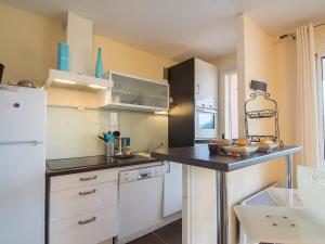 a kitchen with white cabinets and a black counter top at Apartment Porto di Mar-5 by Interhome in Cavalaire-sur-Mer