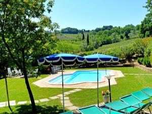 een zwembad met blauwe parasols en stoelen eromheen bij Holiday Home Casa dei Ciliegi by Interhome in Querce