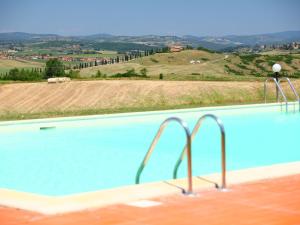 einen Pool mit Blick auf einen Bauernhof und ein Feld in der Unterkunft Apartment Staffolino by Interhome in Casetta