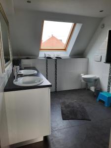 a bathroom with a sink and a window at Au bonheur des hirondelles in Kirrwiller