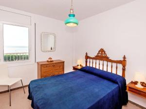 マルグラット・デ・マルにあるApartment Paisos Catalans by Interhomeのベッドルーム(青いベッド1台、窓付)