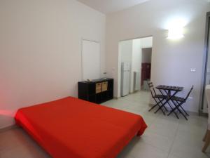 1 dormitorio con cama roja y mesa en Apartment Ada by Interhome, en Castro di Lecce