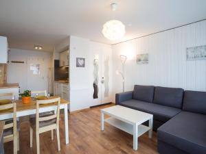 a living room with a blue couch and a table at Studio Greppon 107 by Interhome in Les Collons