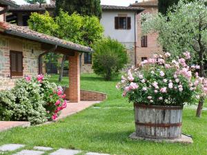 a barrel of flowers in the yard of a house at Holiday Home Casa Graziani-5 by Interhome in Ravigliano