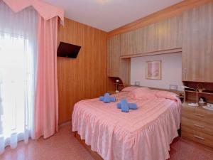 Un dormitorio con una cama grande con sillas azules. en Apartment Edificio Garcomar I by Interhome, en Segur de Calafell