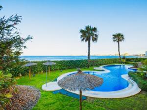 una piscina con sombrilla y el océano en Apartment Punta Cormoran by Interhome, en La Manga del Mar Menor