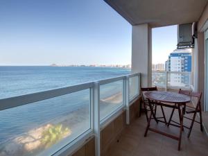 balcón con mesa y vistas al océano en Apartment Punta Cormoran by Interhome, en La Manga del Mar Menor
