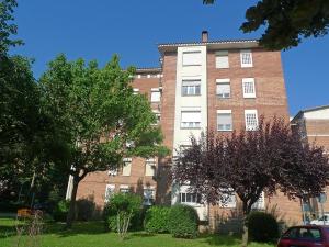 un gran edificio de ladrillo con árboles delante de él en Apartment Olot by Interhome, en Olot