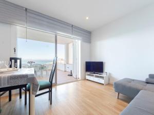 a living room with a table and a couch and a television at Apartment Rits-1 by Interhome in Salou